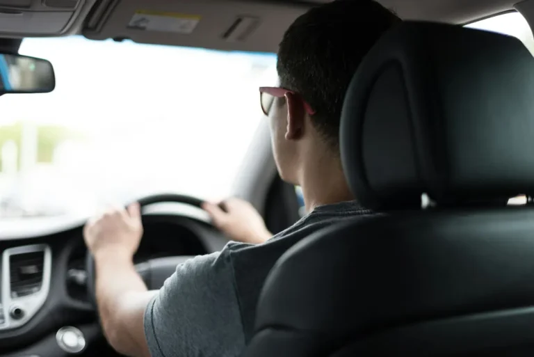 Conductor manejando su carro asegurado